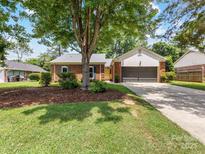 Charming brick home with well-maintained lawn and mature tree providing shade in the front yard at 1115 Berry Ridge Rd, Charlotte, NC 28270