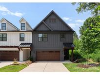 Charming two-story home featuring vertical siding, a stylish brown garage door, and inviting curb appeal at 1517 Falcon St, Charlotte, NC 28211