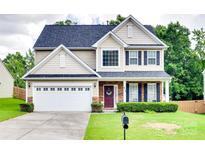 Charming two-story home with a well-manicured lawn, two-car garage, and inviting front porch perfect for relaxation at 1930 Caprington Dr, Fort Mill, SC 29707