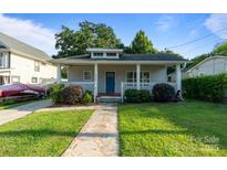 Charming home featuring a cozy front porch, stone walkway and a well-manicured lawn at 215 Cedar St, Belmont, NC 28012