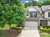Charming two-story townhome featuring a stone accent front, two-car garage, and well-manicured landscaping at 2203 Whitford Ln, Charlotte, NC 28210