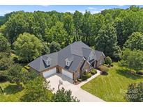 Beautiful brick home with a three-car garage and expansive driveway and mature landscaping at 2818 Levinfield Ct, Lincolnton, NC 28092