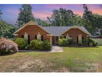 Charming brick home with a well-manicured lawn and lush landscaping at 2916 Northwood Dr, Monroe, NC 28110