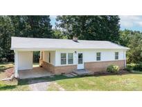 Inviting home with charming architectural details, a covered carport, and a well-maintained yard at 326 Gorrell St, Shelby, NC 28152