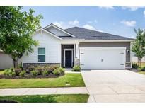 Charming home with a manicured lawn, two-car garage and stylish exterior elements at 3313 Plum Dr, Monroe, NC 28110