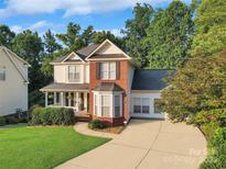 Charming two-story home with a welcoming front porch and a well-manicured lawn in a desirable neighborhood at 3705 Chesapeake Pl, Waxhaw, NC 28173