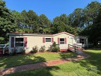 Charming single-story home featuring a red roof, ramp access, and a well-manicured lawn at 44112 Harper Hearne Rd, New London, NC 28127