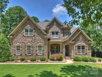 Beautiful stone-clad house with a manicured lawn and mature trees showcasing its curb appeal at 631 May Green Dr, Clover, SC 29710