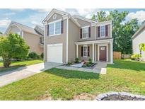 Charming two-story home with a well-manicured lawn and colorful flowerbed near the front door at 6430 Matlea Ct, Charlotte, NC 28215