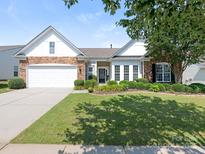 Charming single-story home featuring a stone facade, manicured lawn, and attached two-car garage at 7057 Shenandoah Dr, Fort Mill, SC 29707