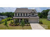 Charming two-story home with a manicured lawn, covered front porch, and attached two-car garage at 7058 Cloer Ct, Charlotte, NC 28214