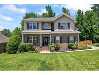 Charming two-story home featuring a well-manicured lawn and a welcoming front porch, creating an inviting curb appeal at 7355 Drury Ln, Denver, NC 28037