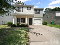 Charming two-story home with a welcoming front porch and attached one car garage at 8516 Paw Valley Ln, Charlotte, NC 28214