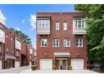 Beautiful brick townhome with two-car garage and decorative awnings in a desirable neighborhood at 106 N Laurel Ave # 118, Charlotte, NC 28207