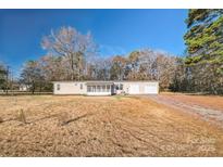 Single story home featuring a front screened in porch and two car garage with a gravel driveway at 1295 Reservation Rd, Rock Hill, SC 29730
