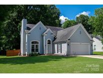 Charming two-story home with well-manicured lawn, blue siding and an attached two-car garage at 14130 Misty Brook Ln, Charlotte, NC 28273
