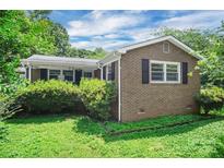 Charming brick home featuring black shutters and a lush green lawn at 2215 Hodgin St, Gastonia, NC 28056