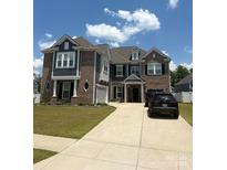 Two-story brick home featuring a well-manicured lawn, driveway, and attached garage on a sunny day at 2960 Haley Cir, Davidson, NC 28036