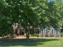 Charming home exterior with a front porch and beautifully landscaped front yard on a sunny day at 3210 Crow Row, Monroe, NC 28112