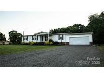 Charming single story home with a gravel driveway and an attached two car garage at 34107 Watson Rd, Albemarle, NC 28001