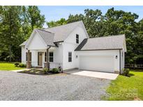 Charming two-story home featuring light siding, a gray roof, and a convenient attached garage at 529 N Central Ave, Locust, NC 28097