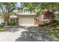 Two-story home with a two-car garage, manicured landscaping, and brick accents at 6602 Gaywind Dr, Charlotte, NC 28226