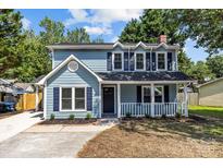 Charming two-story home with blue siding, black shutters, covered porch, and well-maintained landscaping at 7219 Spring Morning Ln, Charlotte, NC 28227