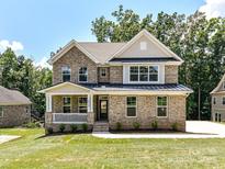 Stunning two-story brick home with a covered front porch and lush green lawn at 7717 Nautical View Dr, Denver, NC 28037