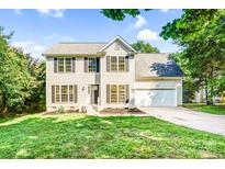Charming two-story home featuring black shutters, a well-manicured lawn, and an attached two-car garage at 953 Milkwood Ln, Monroe, NC 28110