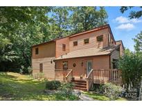 Charming exterior elevation featuring wood siding, a welcoming porch, and lush greenery in a serene setting at 1119 Palmyra Dr, Fort Mill, SC 29708