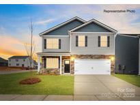 Charming two-story home featuring stone accents, a two-car garage, and a well-manicured lawn at 115 Rustling Waters Dr, Mooresville, NC 28117
