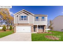 Charming two-story home with a brick and siding exterior, attached garage, and well-manicured lawn at 119 Rustling Waters Dr, Mooresville, NC 28117