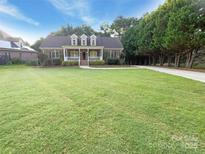 Charming brick home featuring a well-manicured lawn, covered porch, and mature trees at 1228 N Dobys Bridge Rd, Fort Mill, SC 29715