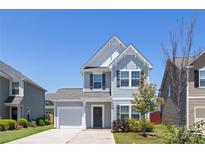 Charming two-story home features a well-manicured lawn and a classic architectural design under a clear blue sky at 12548 Gotland Rd # 327, Midland, NC 28107