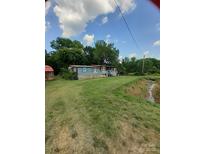 Charming home exterior with blue siding, a front porch, and a neatly mowed lawn at 3913 Stough Sw Rd, Concord, NC 28027