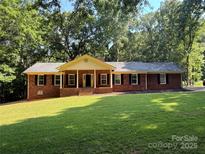 Charming single-story brick home featuring a welcoming front porch and lush green lawn at 3943 Peggy Ln, Mint Hill, NC 28227