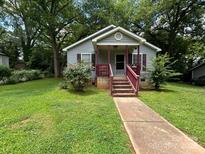 Charming single-story home featuring a cozy front porch and a well-maintained front yard at 407 Alton St, Monroe, NC 28110