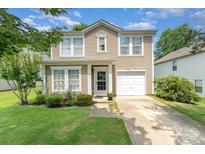 Charming two-story home featuring a well-manicured lawn, tidy landscaping, and a one-car garage at 4462 Kellybrook Dr, Concord, NC 28025