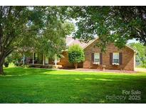 Charming brick home featuring a well-manicured front lawn, mature trees, and inviting curb appeal at 5172 Butner Dr, Hickory, NC 28602