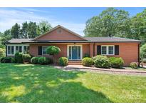 Charming brick home with a well-manicured lawn and a welcoming blue front door at 747 9Th Nw St, Hickory, NC 28601