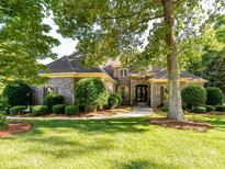 Charming brick home featuring mature landscaping, a manicured lawn, and elegant architectural details at 9000 Whirlaway Ln, Waxhaw, NC 28173