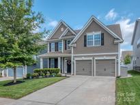 Charming two-story home with a well-manicured lawn and a two-car garage at 124 W Americana Dr, Mooresville, NC 28115