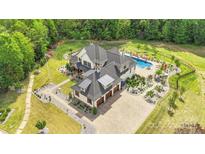 Expansive estate with a luxurious pool, meticulously landscaped grounds, and a private three-car garage at 1430 Rosehill Dr, Waxhaw, NC 28173