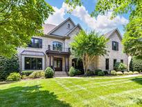 Stately brick home featuring a manicured lawn, covered entryway, and second story balcony at 18618 Rollingdale Ln, Davidson, NC 28036