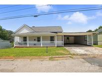 Charming home featuring a covered porch, a connected carport, and a well-maintained front lawn at 310 Sidney Johnson St, Fort Mill, SC 29715