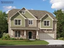 Inviting two-story home with stone accents, green siding, and a well-manicured lawn at 3823 Horsham St, Indian Land, SC 29707