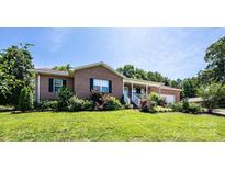 Charming brick home with a covered front porch, well-maintained lawn, and established landscaping at 4128 River Run Cir, Hickory, NC 28602