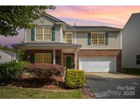 Charming two-story home featuring green shutters, brick accents, and a well-manicured front yard at 4732 Meadowfield Rd # L35, Charlotte, NC 28215