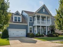 Charming two-story home featuring a covered front porch, attached garage, and manicured lawn at 500 Landau Rd, Waxhaw, NC 28173