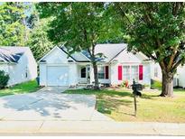 Charming single-story home with well-manicured lawn, mature trees, and a private driveway at 7215 Wingstone Ln, Charlotte, NC 28262